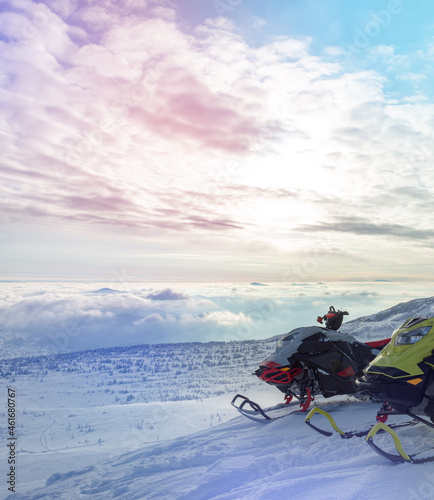 two professional sports snowmobiles on the top of the mountain in the morning without a rider. the concept of advertising recreation and travel on snow bikes. high quality photos