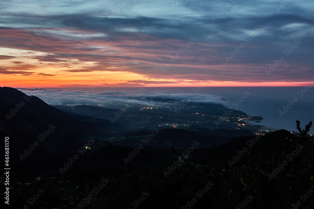 Clouds descend over Playa de la Isla at sunset. Asturias. Spain