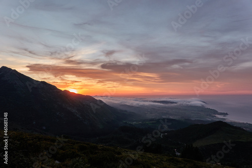 Clouds descend over Playa de la Isla at sunset. Asturias. Spain