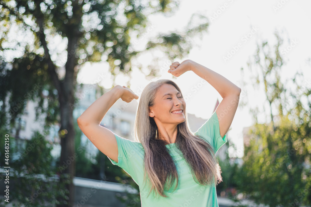 Photo of carefree serene peaceful pensioner lady enjoy sunny day stretch wear turquoise t-shirt urban city outside Photo of carefree serene peaceful pensioner lady enjoy sunny day stretch wear turquoise t-shirt urban city outside