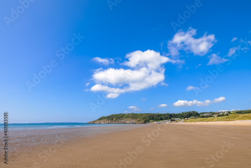 An idyllic beach setting with deep blue seas and bright blue sky