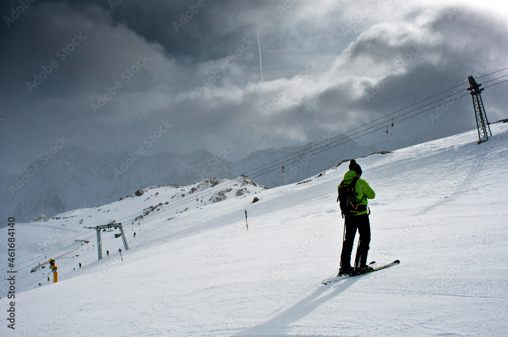 A skier drives down the piste