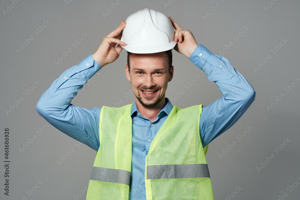 man in white helmet blueprints builder light background