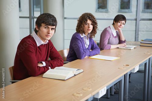 Portrait of students at desk in library