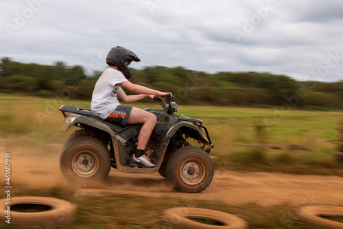 A young boy quad biking on the dusty hills of South Wales