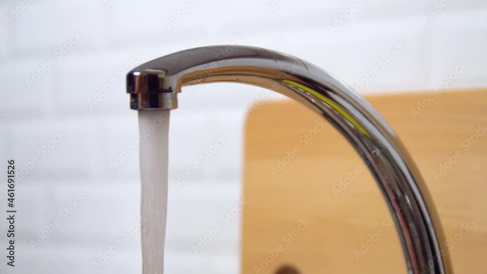Close-up of water running from kitchen sink faucet Close-up of water running from kitchen sink faucet