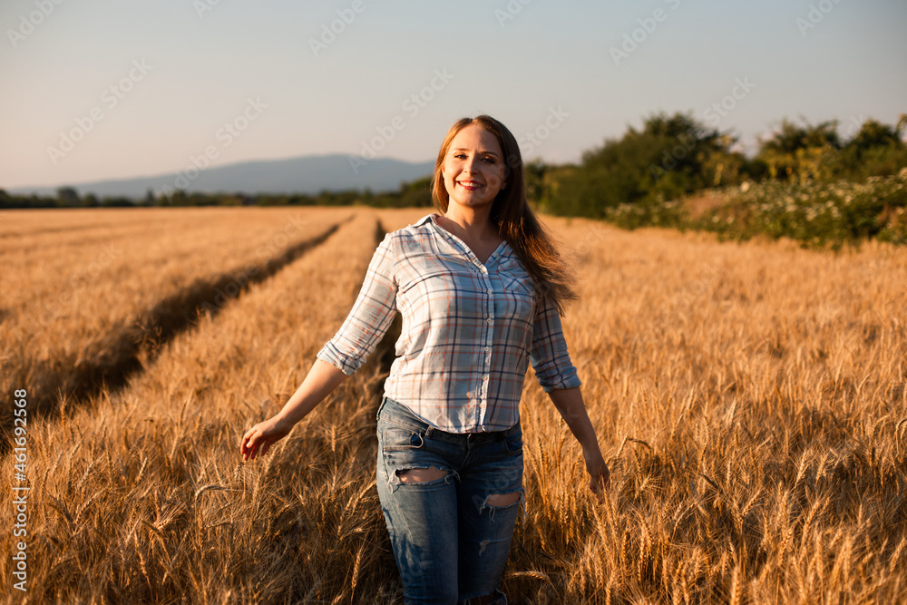 Charming woman enjoying moment, walking in grain field Charming woman enjoying moment, walking in grain field