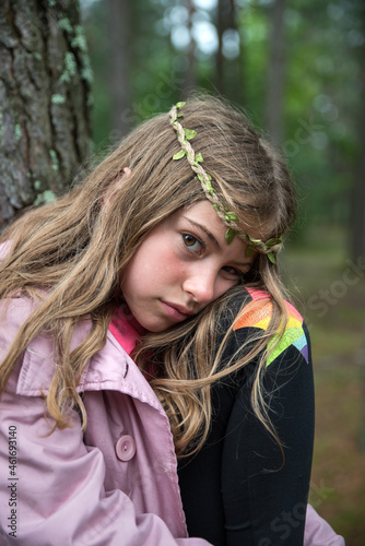 Sad girl in the woods among the trees.