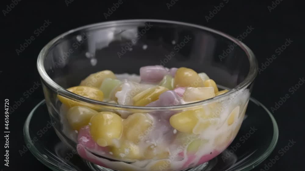 Pouring sticky rice balls, ginkgo fruit and coconut meat into transparent bowl and follow by sweet coconut milk. Thai dessert, Boi loy, with ginkgo and coconut meat in sweet coconut milk. Pouring sticky rice balls, ginkgo fruit and coconut meat into transparent bowl and follow by sweet coconut milk. Thai dessert, Boi loy, with ginkgo and coconut meat in sweet coconut milk.