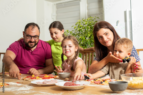 the young family prepares pizza together at home