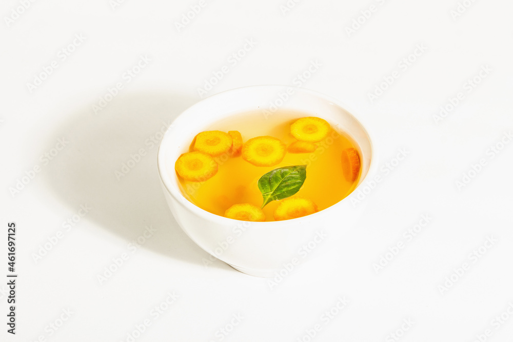 Transparent chicken broth with vegetables in ceramic bowls Transparent chicken broth with vegetables in ceramic bowls