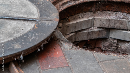 Blocked sewer drain. The water of recycling. Uninstalling septic tank with old iron manhole.