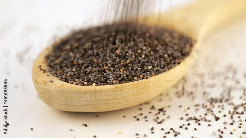 Dry oregano strewed from above into a wooden scoop Dry oregano strewed from above into a wooden scoop