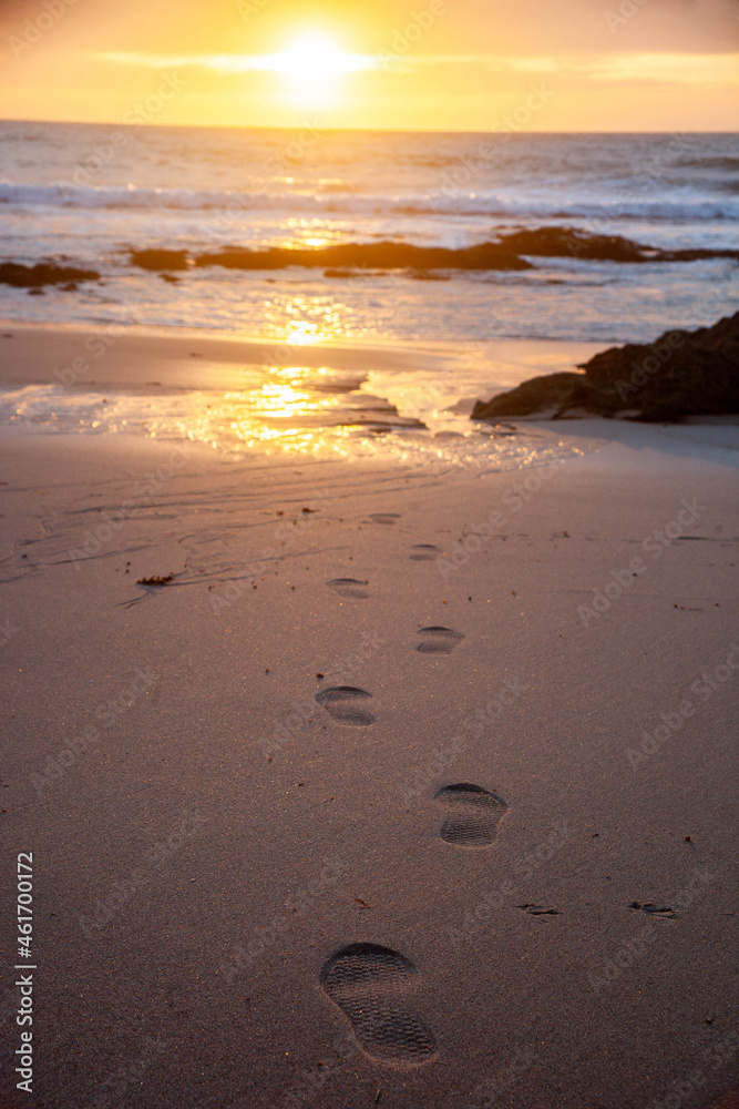 Footprints in the wet sand, with the sunset in the background. Footprints in the wet sand, with the sunset in the background.