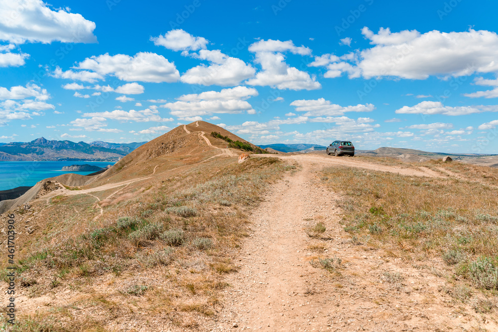 Beautiful landscape of mountainous terrain with hills against a blue sky with clouds Beautiful landscape of mountainous terrain with hills against a blue sky with clouds