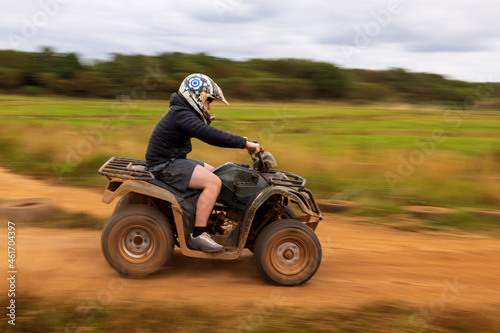A young boy quad biking on the dusty hills of South Wales