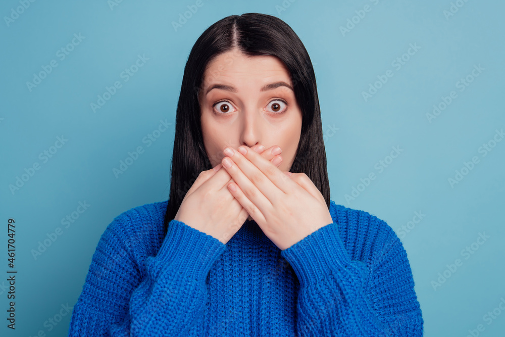 Close-up portrait of nice attractive girl shocked closing mouth oops fail tell secret isolated over blue color background Close-up portrait of nice attractive girl shocked closing mouth oops fail tell secret isolated over blue color background