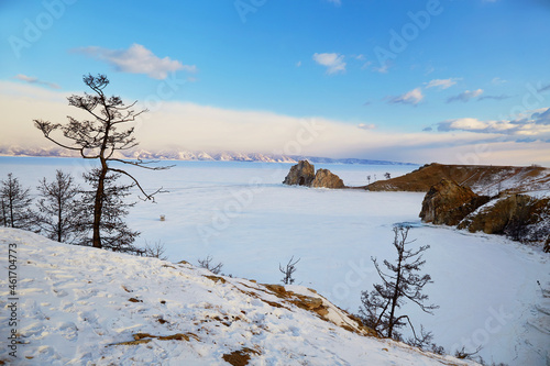View of Cape Burhan or Shaman rock on Olkhon island in winter. Frozen Lake Baikal, snow on the surface of the ice.