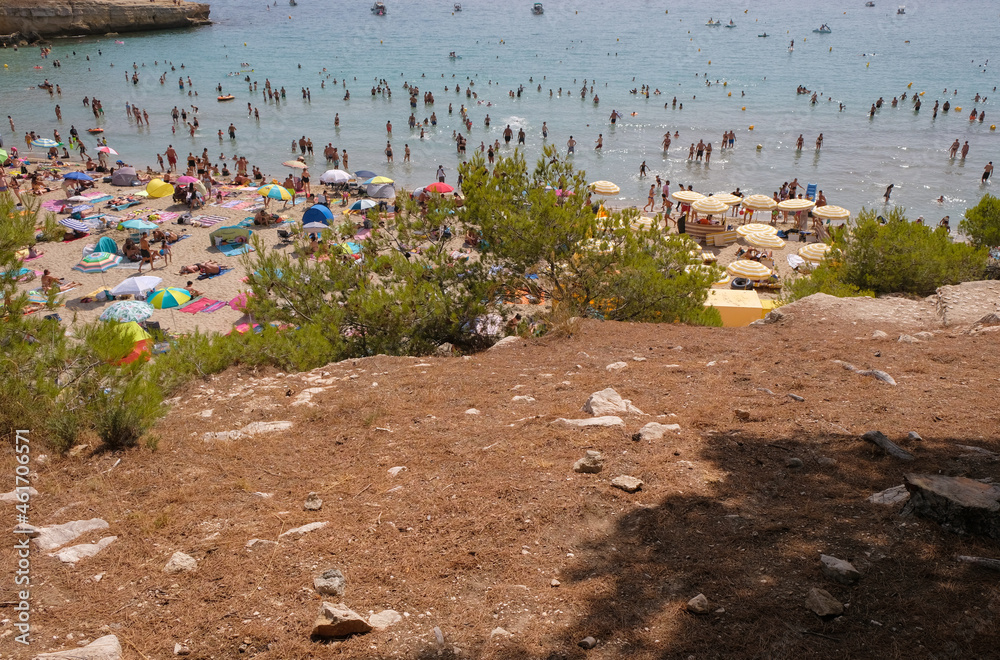 Sainte-Croix beach, Provence, France. August 14, 2021. Top view of the sea beach. Bright umbrellas and happy vacationers. Copy space. 
