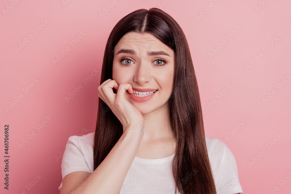 Close up portrait of sweet charming girl unhappy sad upset nervous bite fingers teeth isolated pink color background Close up portrait of sweet charming girl unhappy sad upset nervous bite fingers teeth isolated pink color background