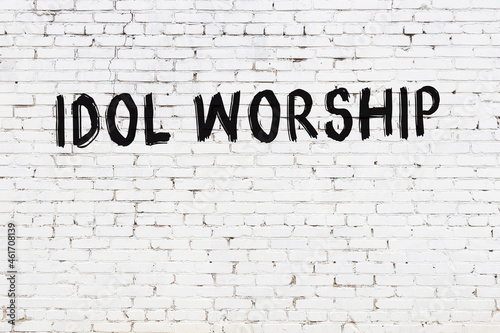 Photos White wall with black paint inscription idol worship on it