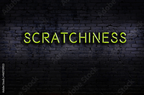 Night view of neon sign on brick wall with inscription scratchiness photo