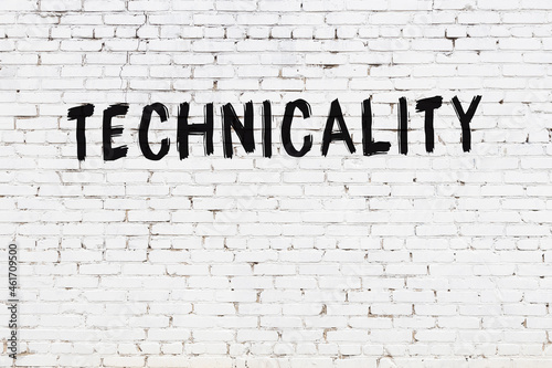Inscription technicality painted on white brick wall