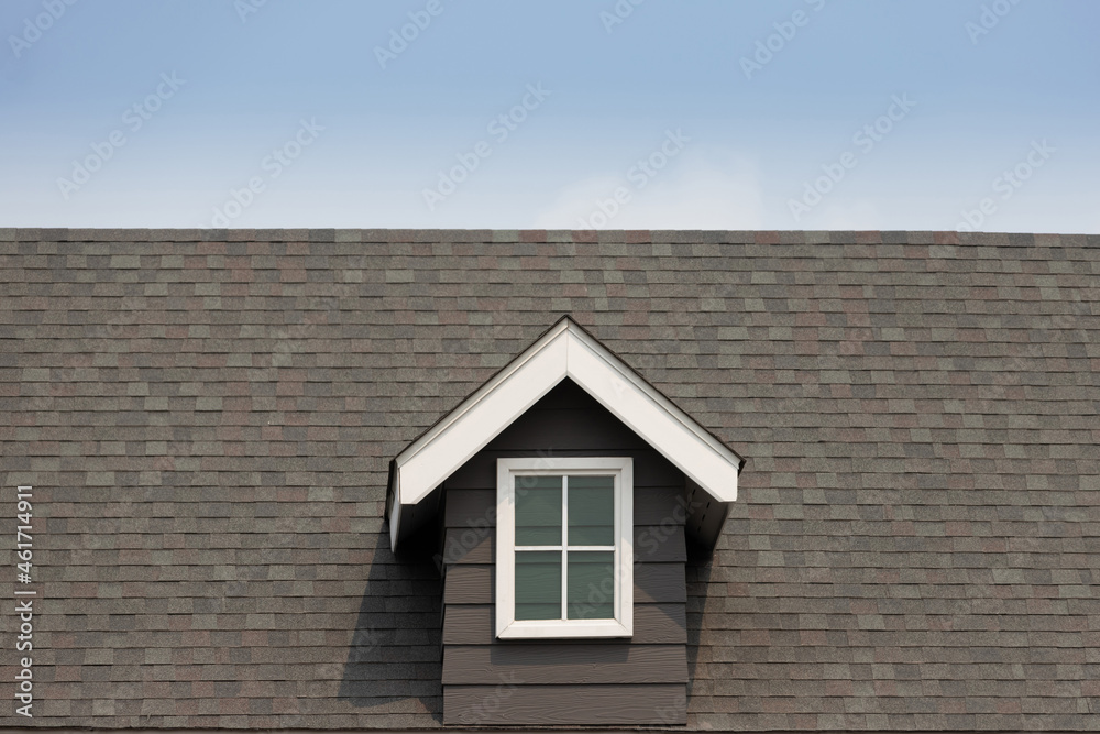fake window on garret house and roof shingle with blue sky background. Asphalt Shingles or Bitumen Tiles.