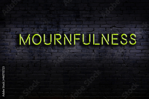 Night view of neon sign on brick wall with inscription mournfulness photo