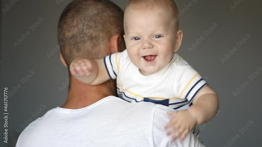 Adorable infant laughs in an daddy's embrace Adorable infant laughs in an daddy's embrace