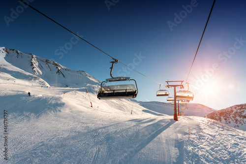 Φωτογραφία Ski lift empty ropeway on hilghland alpine mountain winter resort on bright sunny evening