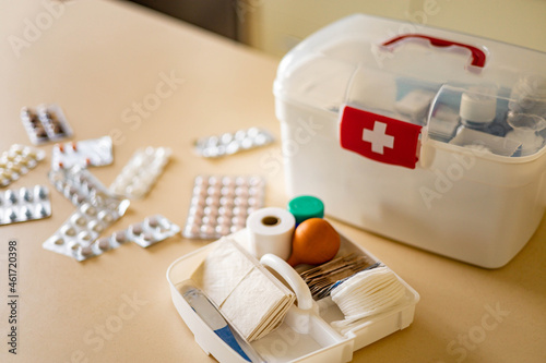 Closeup female hand placing medicament domestic first aid kit. Storage organization emergency supply photo