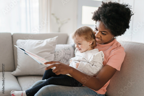 Tableau sur toile nursery babysitter with baby reading a book