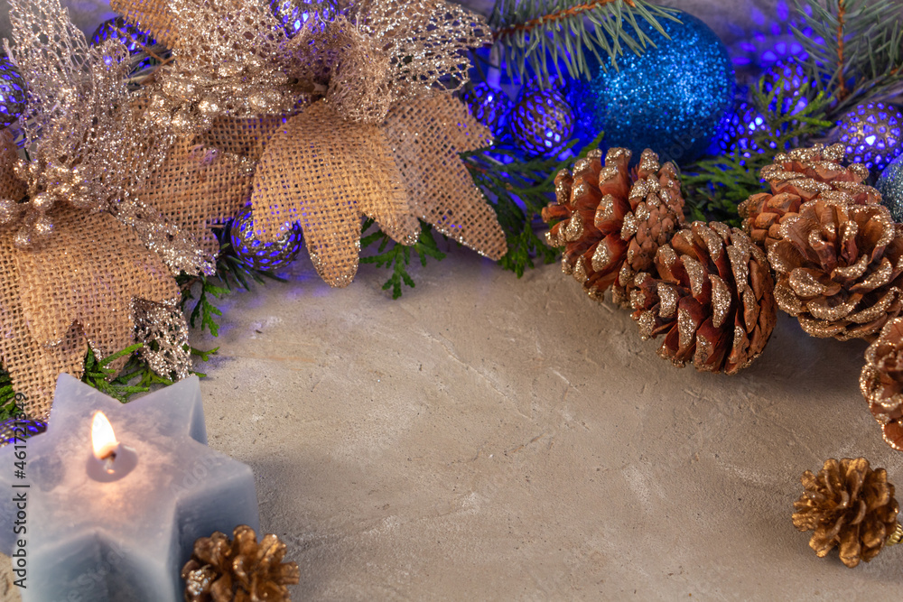 Fototapeta premium christmas composition in silver blue color, blue garland, spruce branches, candle on gray background, copy space