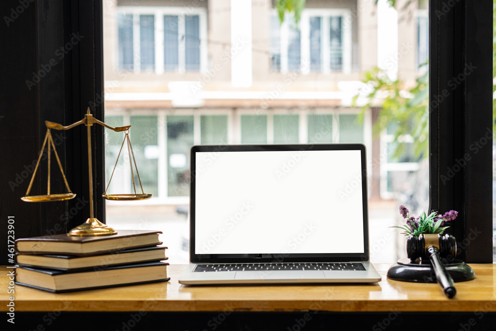 Fototapeta premium Laptop and judge's hammer and scales ah justice with notebook on lawyer's desk in legal concept office