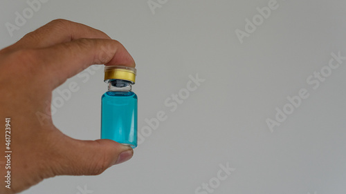 a doctor holding a vaccine to the patient in his hand to pick up a bottle of medicine with liquid medicine white background