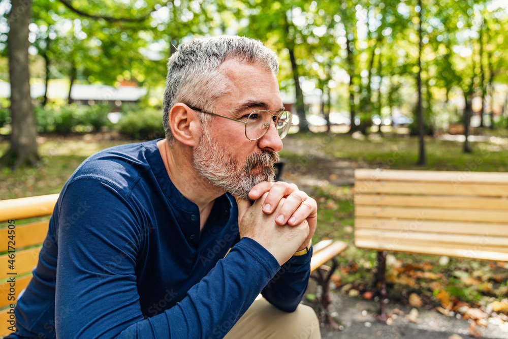 Portrait of a mature man sitting on a bench in an urban park Portrait of a mature man sitting on a bench in an urban park