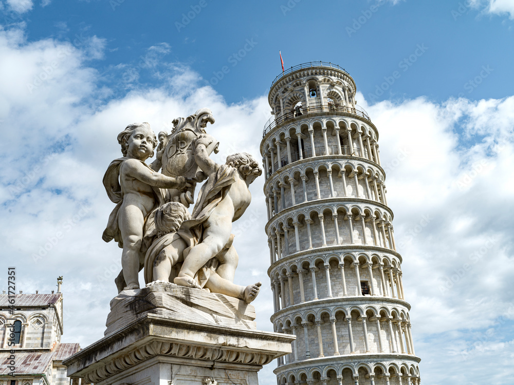 Monument with cherubs with background of the tower of Pisa in Italy 