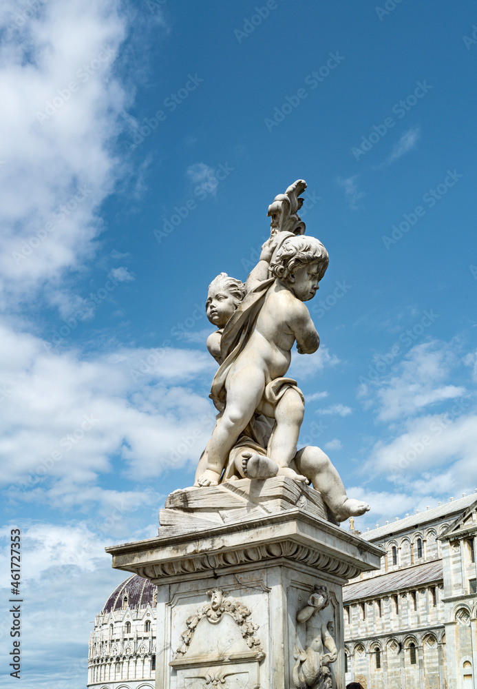 Monument with cherubs in front of the cathedral of Pisa in Italy 