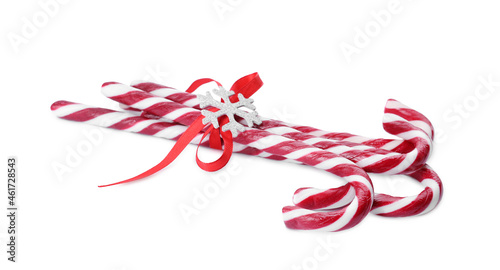 Sweet Christmas candy canes with red bow and snowflake on white background
