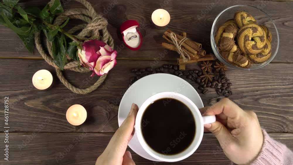 A woman takes a white cup of coffee from a romantically decorated table for Valentine's Day.4k A woman takes a white cup of coffee from a romantically decorated table for Valentine's Day.4k