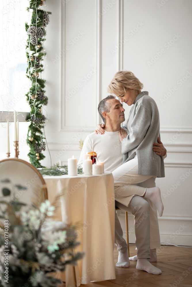 adult man and woman hugging sitting near a round festive table adult man and woman hugging sitting near a round festive table
