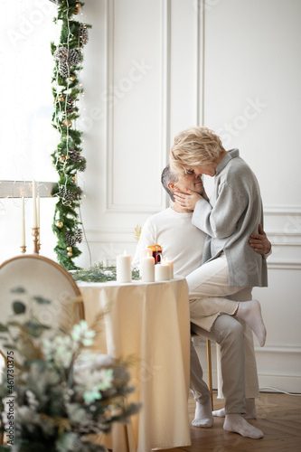 adult man and woman hugging sitting near a round festive table