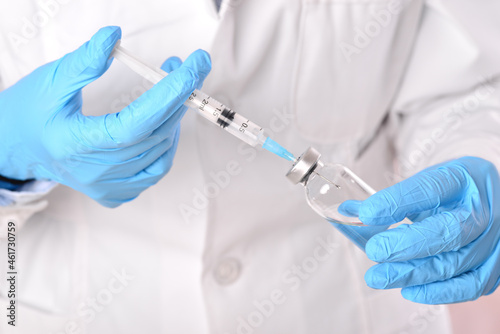A woman doctor holds a syringe in front of the ward