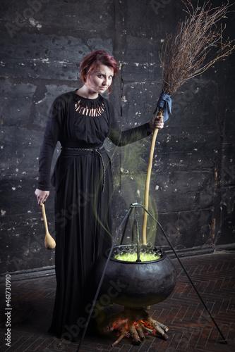 Young beautiful witch preparing a potion for Halloween 