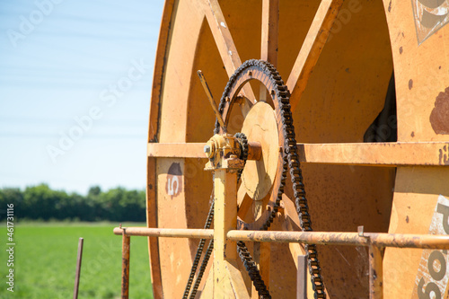 Closeup of the chain drive on the orange metal wheel. photo