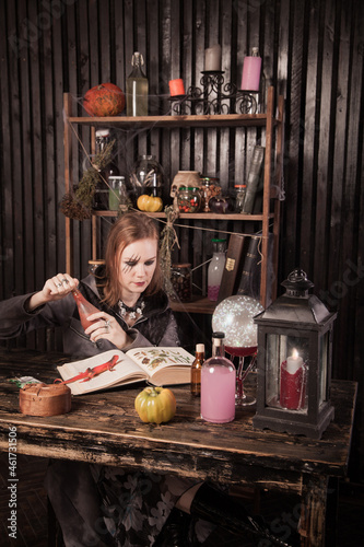 Young beautiful witch read a book at Halloween 