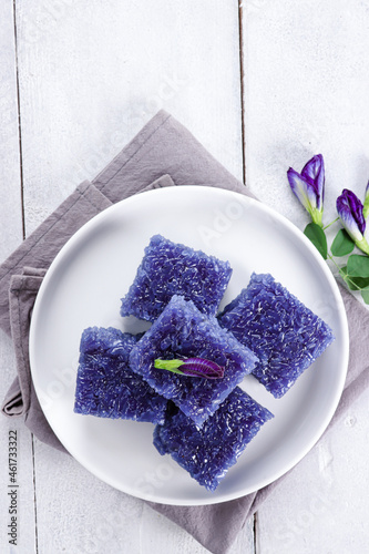 Wajik ketan bunga telang or Wajit Ngora is traditional Indonesian snack made with steamed sticky glutinous rice cooked in Sugar, coconut milk, and bluepea flower juice.  photo