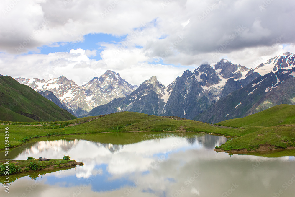 The Caucasus mountains and clouds are reflected in the mountain Koruldi lakes