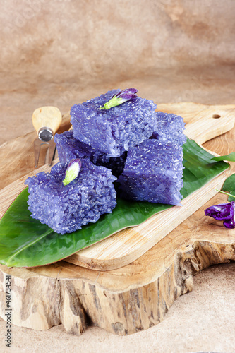 Wajik ketan bunga telang or Wajit Ngora is traditional Indonesian snack made with steamed sticky glutinous rice cooked in Sugar, coconut milk, and bluepea flower juice.  photo